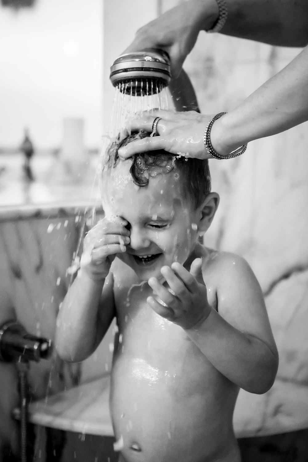 Mom washing her toddler´s hair in the shower
