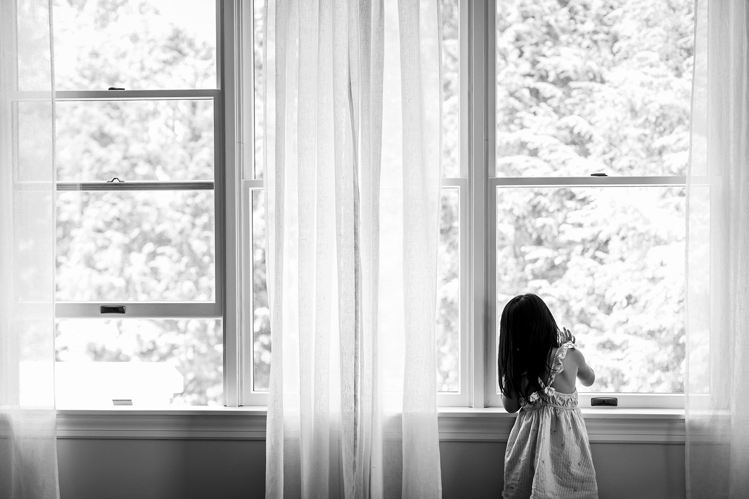 BW little girl looking out the window