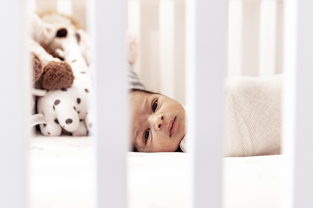 Newborn baby laying in a crib