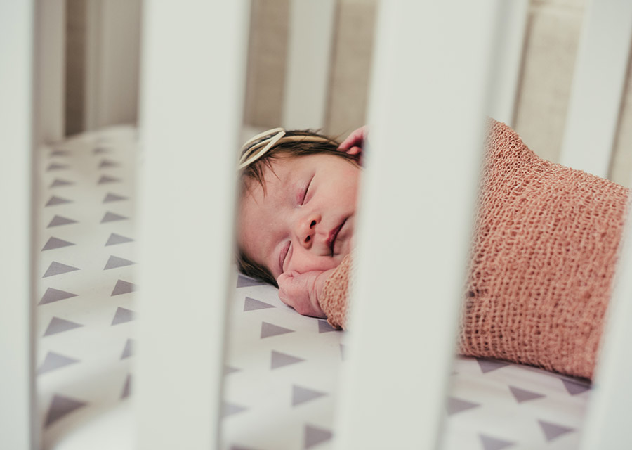 Newborn baby sleeping in a crib