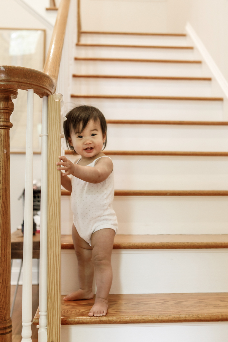 Toddler standing on stairs while looking at the camera