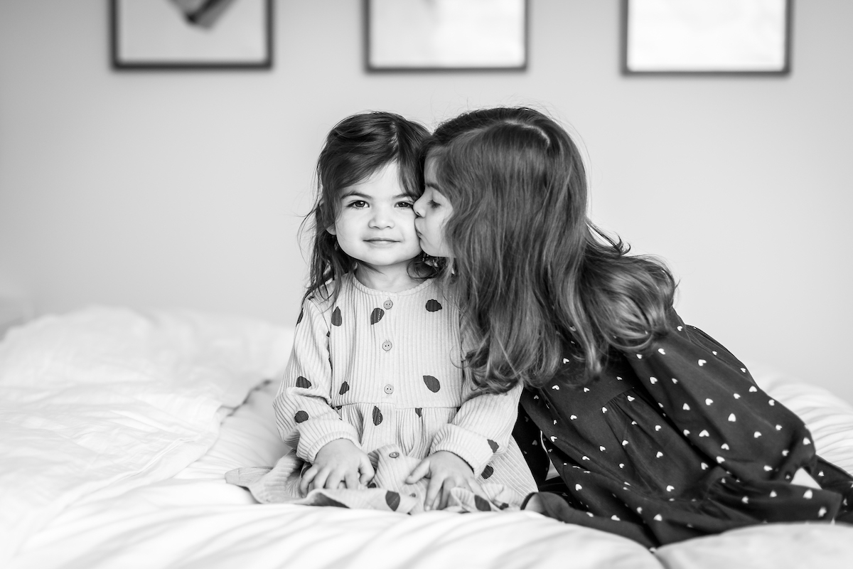 BW Bis sister giving her little sister a kiss on the cheek
