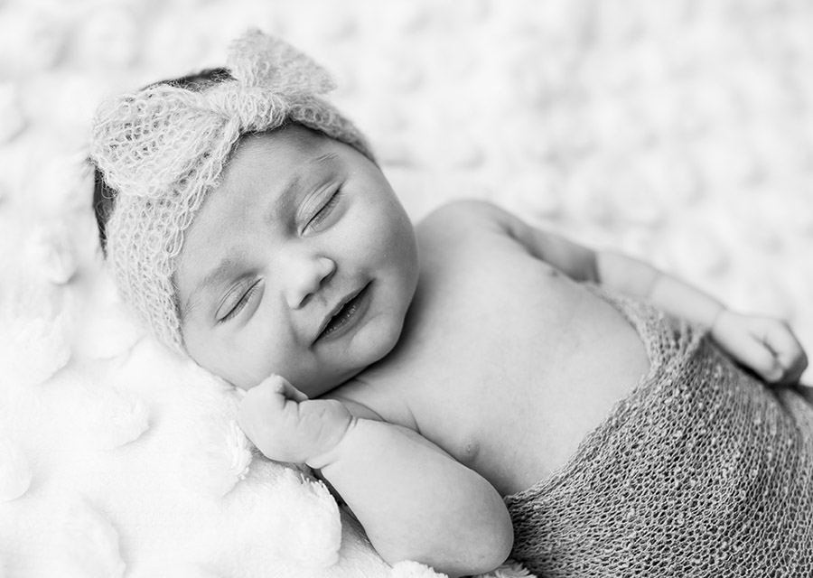 Sleeping newborn baby smiling