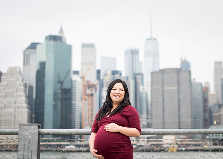 Pregnant woman smiling at the camera in front of skyline