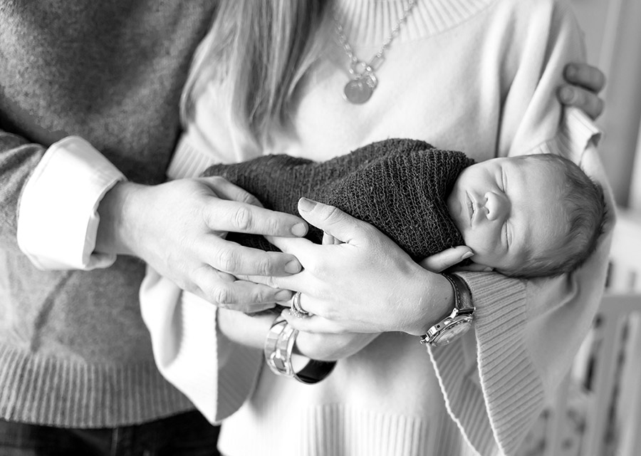 BW Parents arms holding their newborn baby