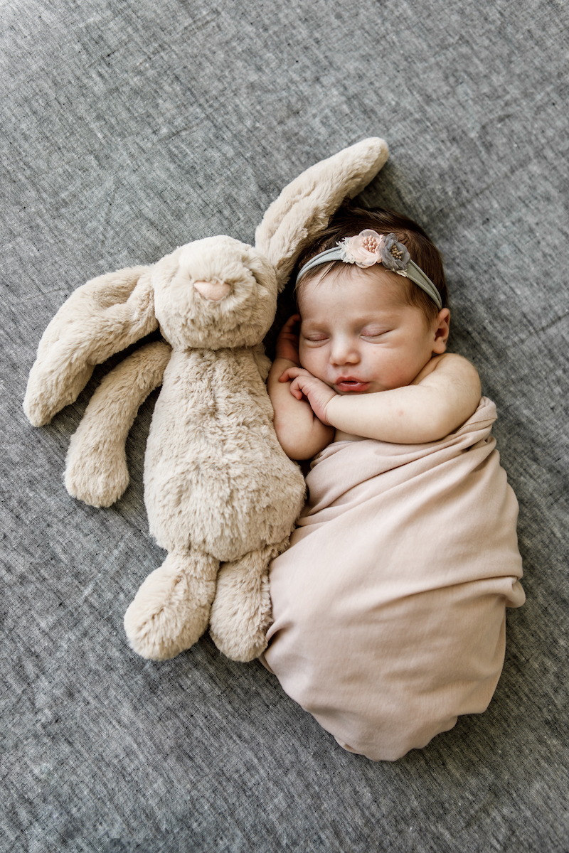 Newborn baby sleeping next to a toy bunny