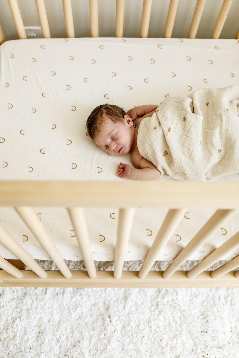 sleeping newborn baby in a crib