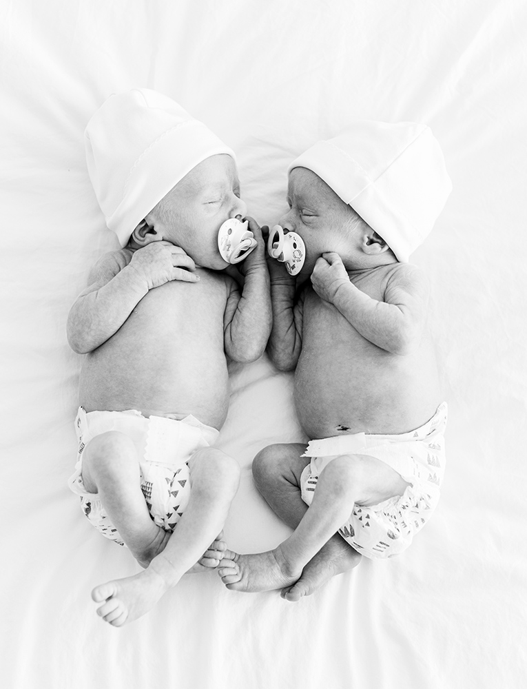 Sleeping newborn twin babies laying next to each other