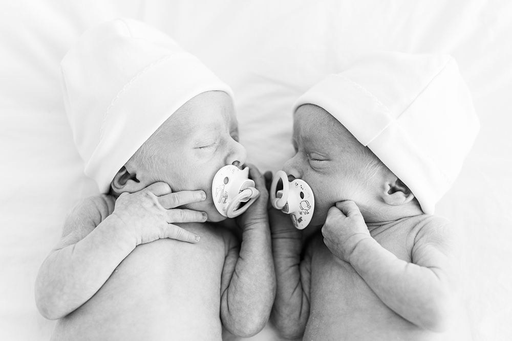 Sleeping newborn twin babies with their heads turned to each other