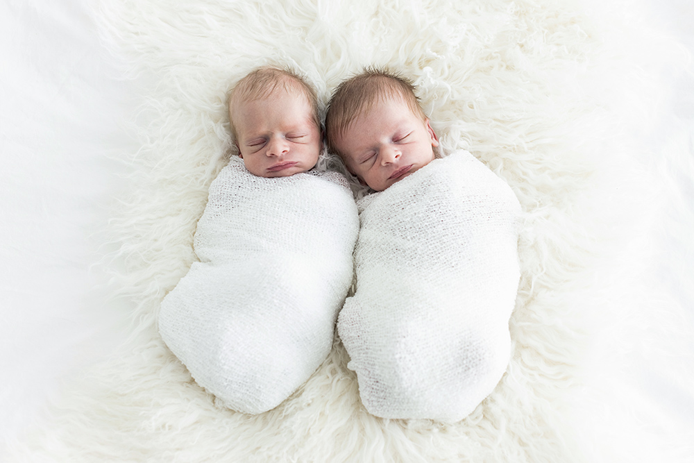 Sleeping newborn twin babies laying next to each other