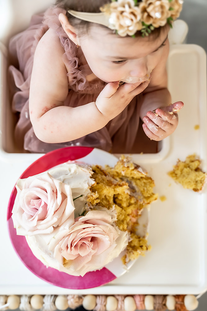 Table top view of girl eating a cake messily