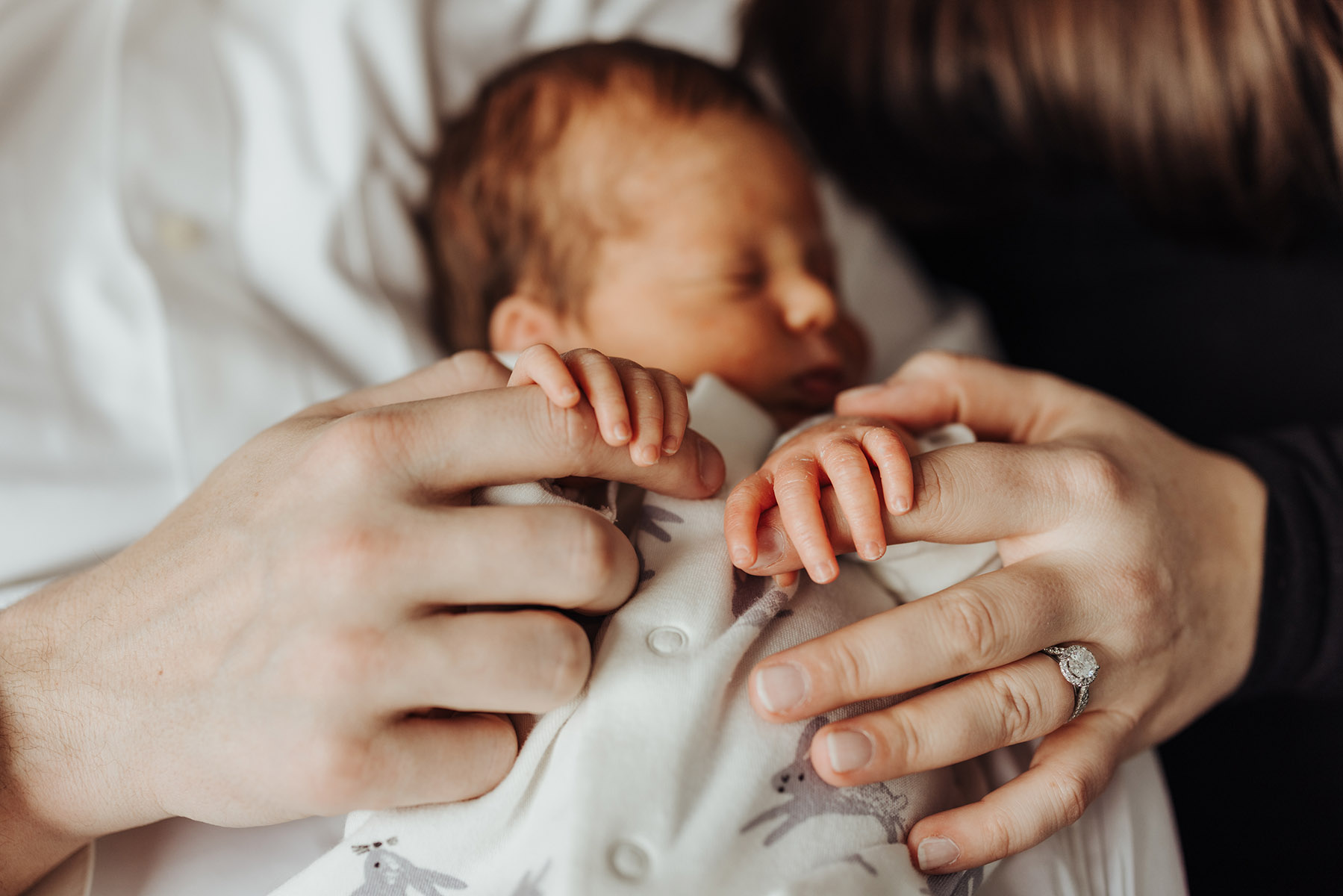 closeup of newborns hands holding parents fingers