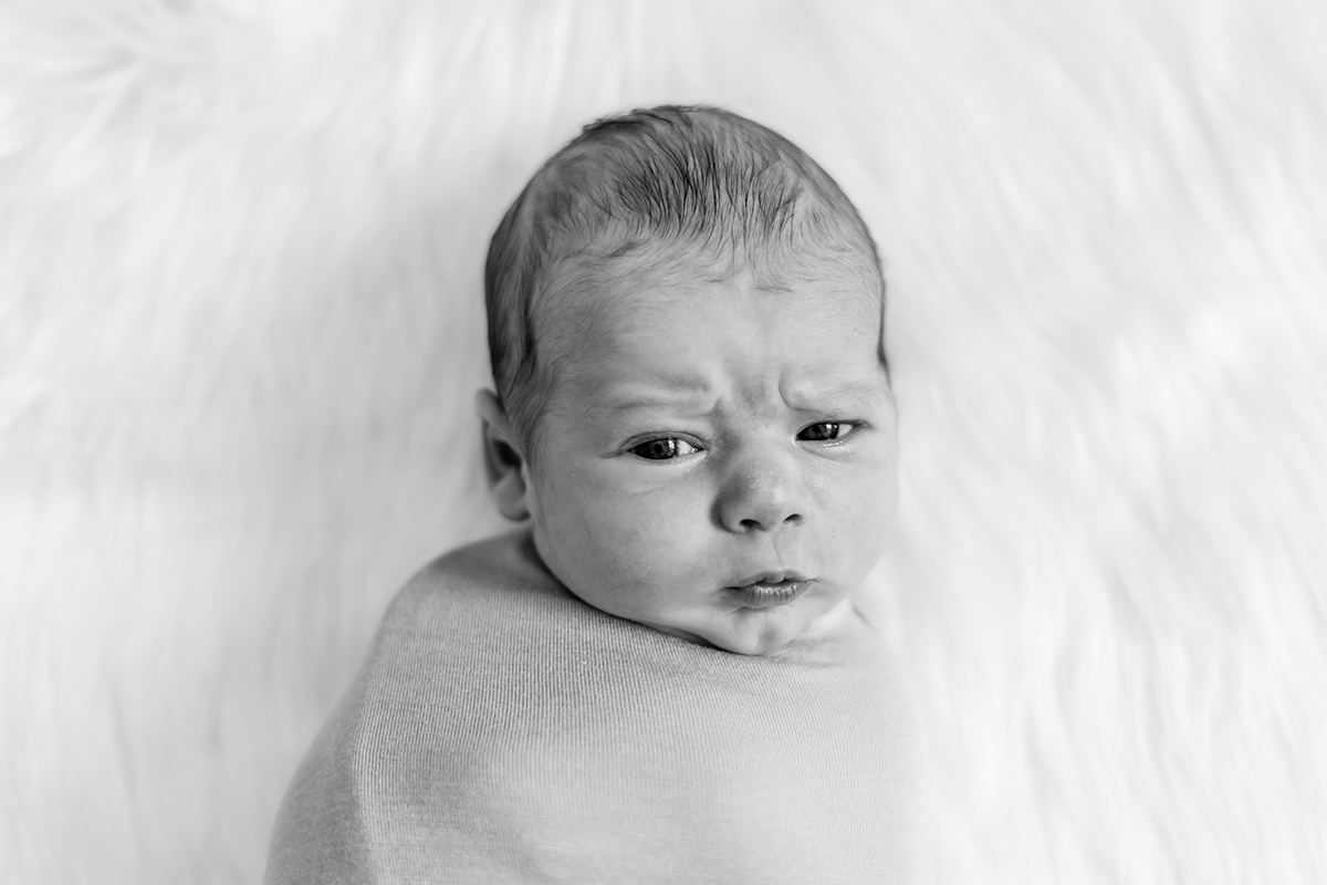 Newborn baby looking into the camera with skeptical eyes
