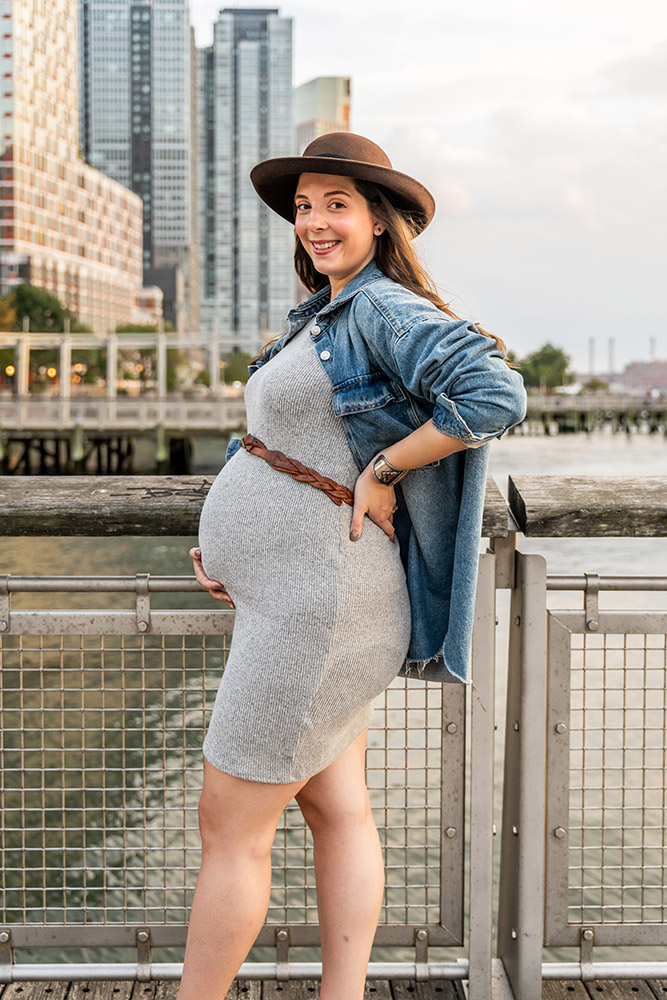 Beautiful pregnant woman with hat on showing off her belly in Williamsburg