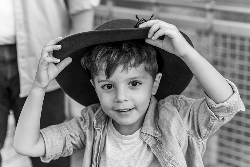 Young boy trying on his mom's hat