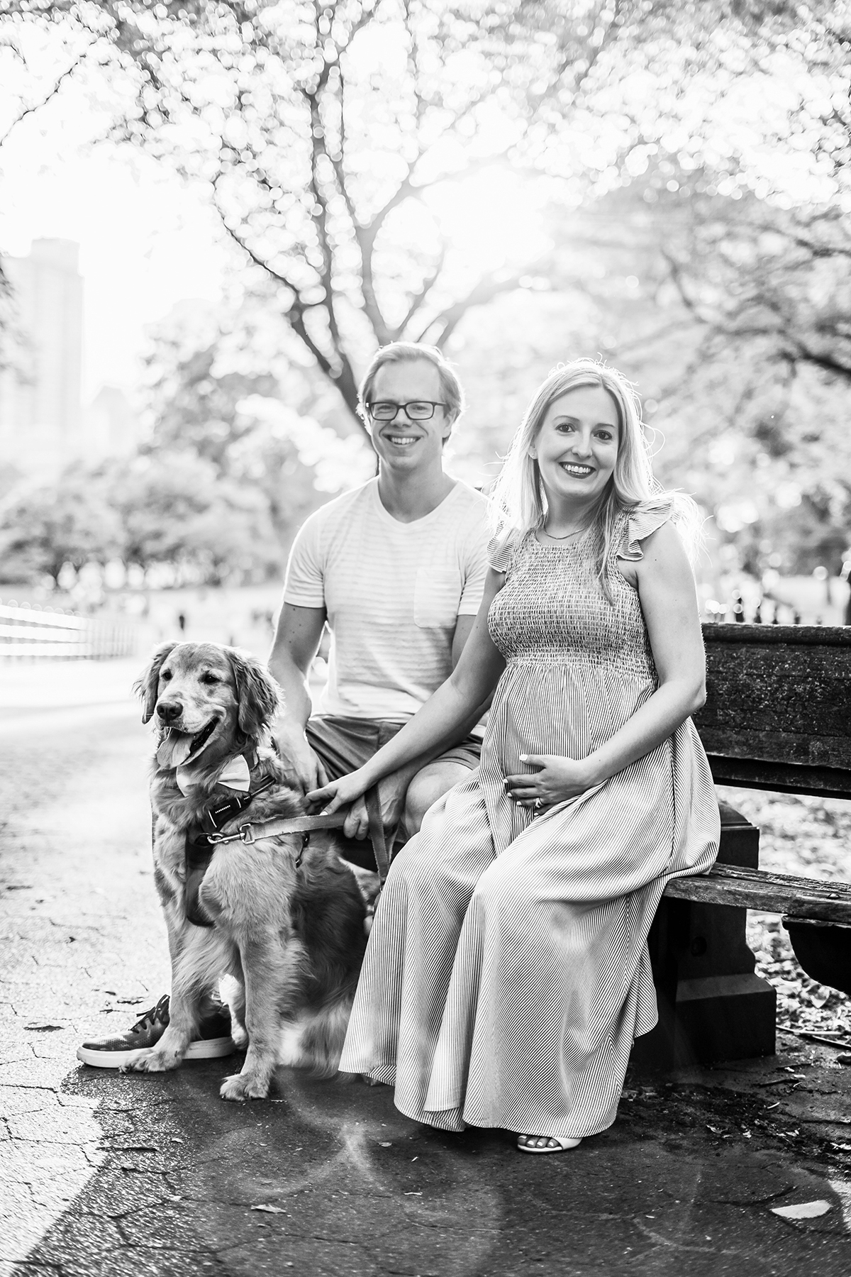 Black and white photo of parents with their dog, woman is pregnant