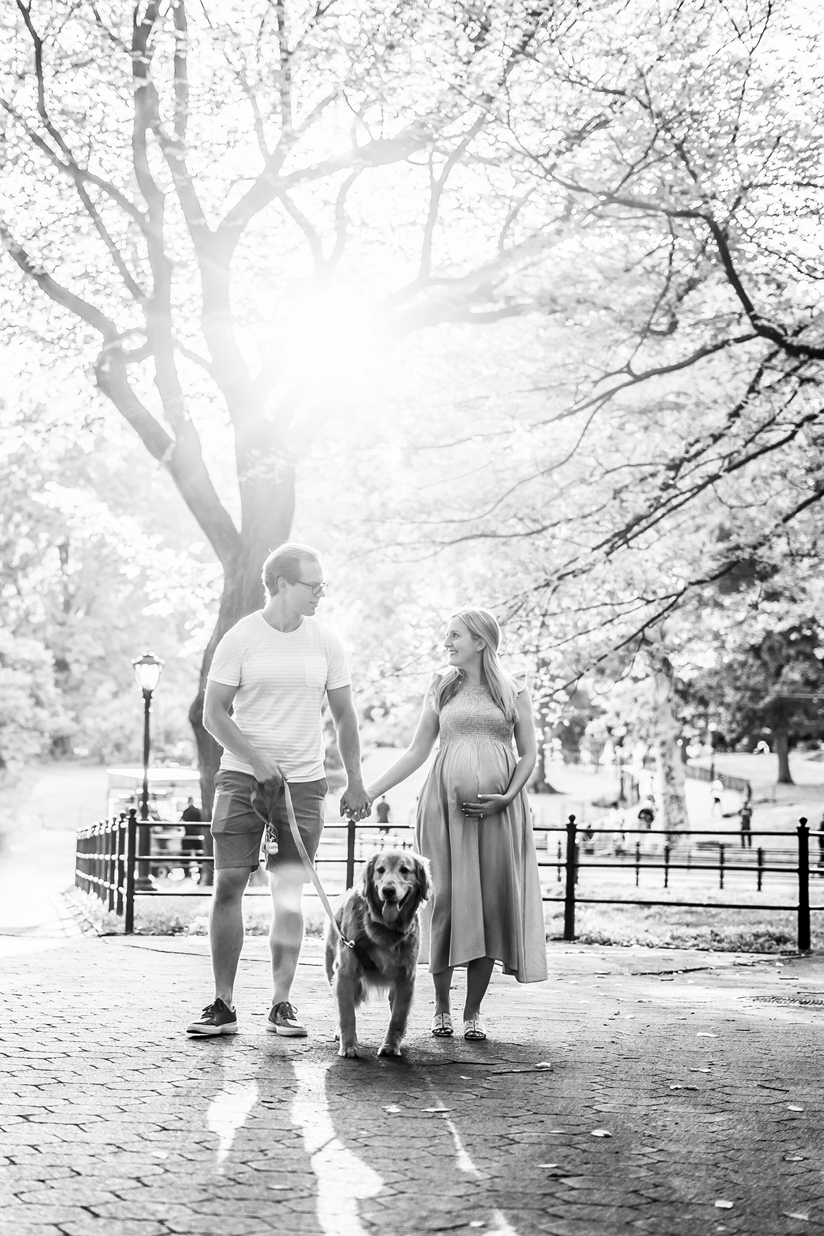 Black and white photo of parents with their dog, woman is pregnant