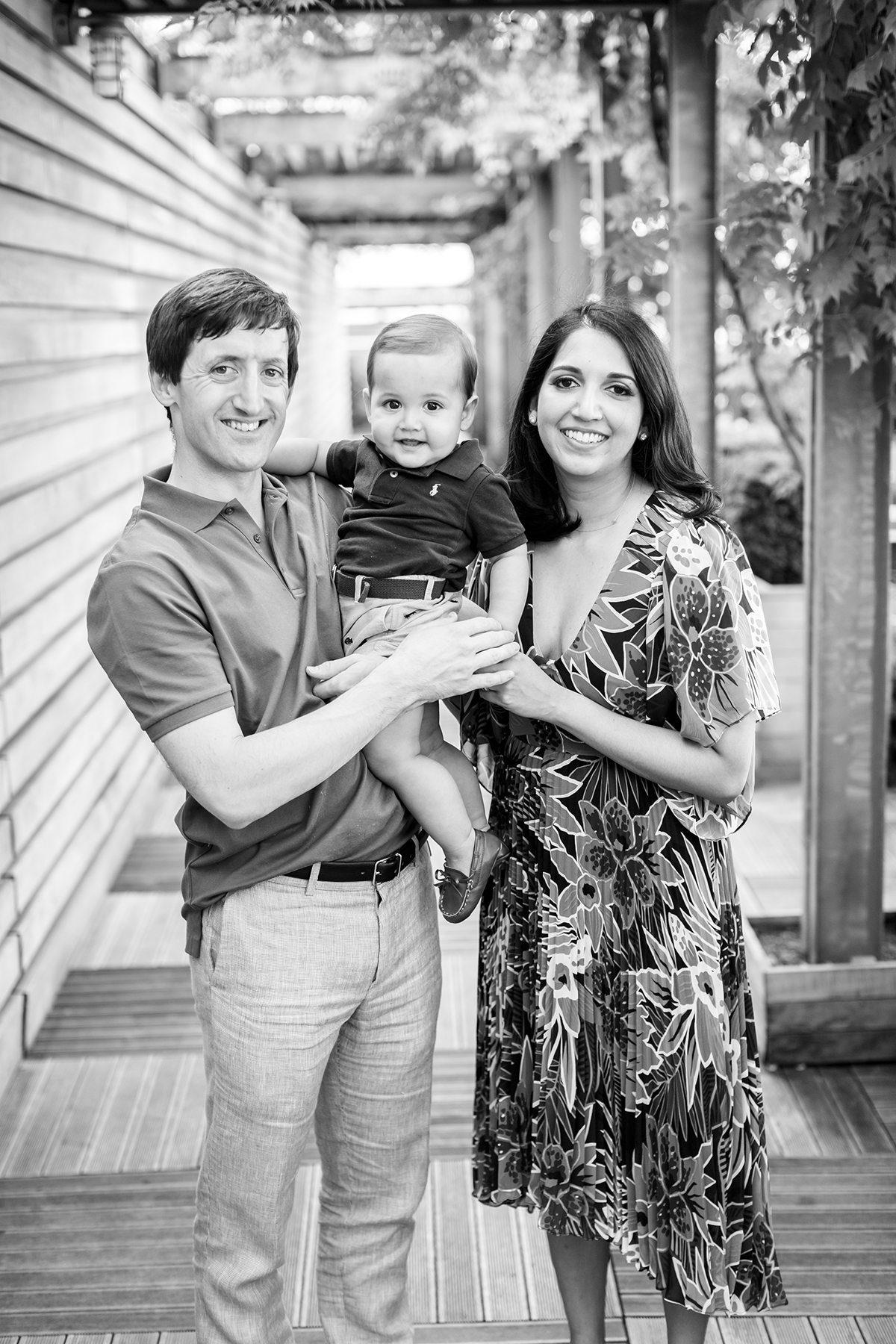 Black and white portrait of parents with their 1 year old smiling to the camera