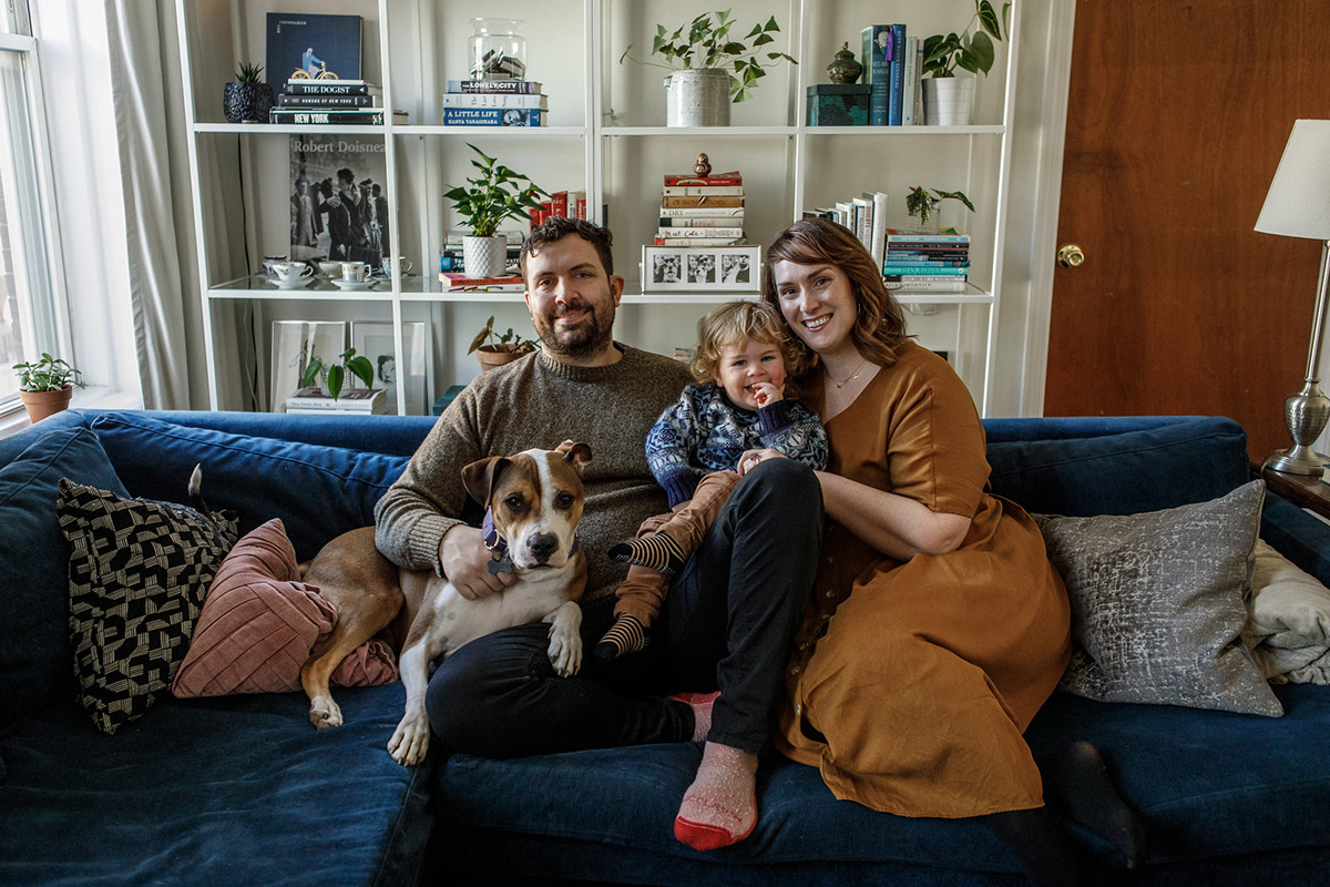 happy family photo with dog on blue couch in brooklyn