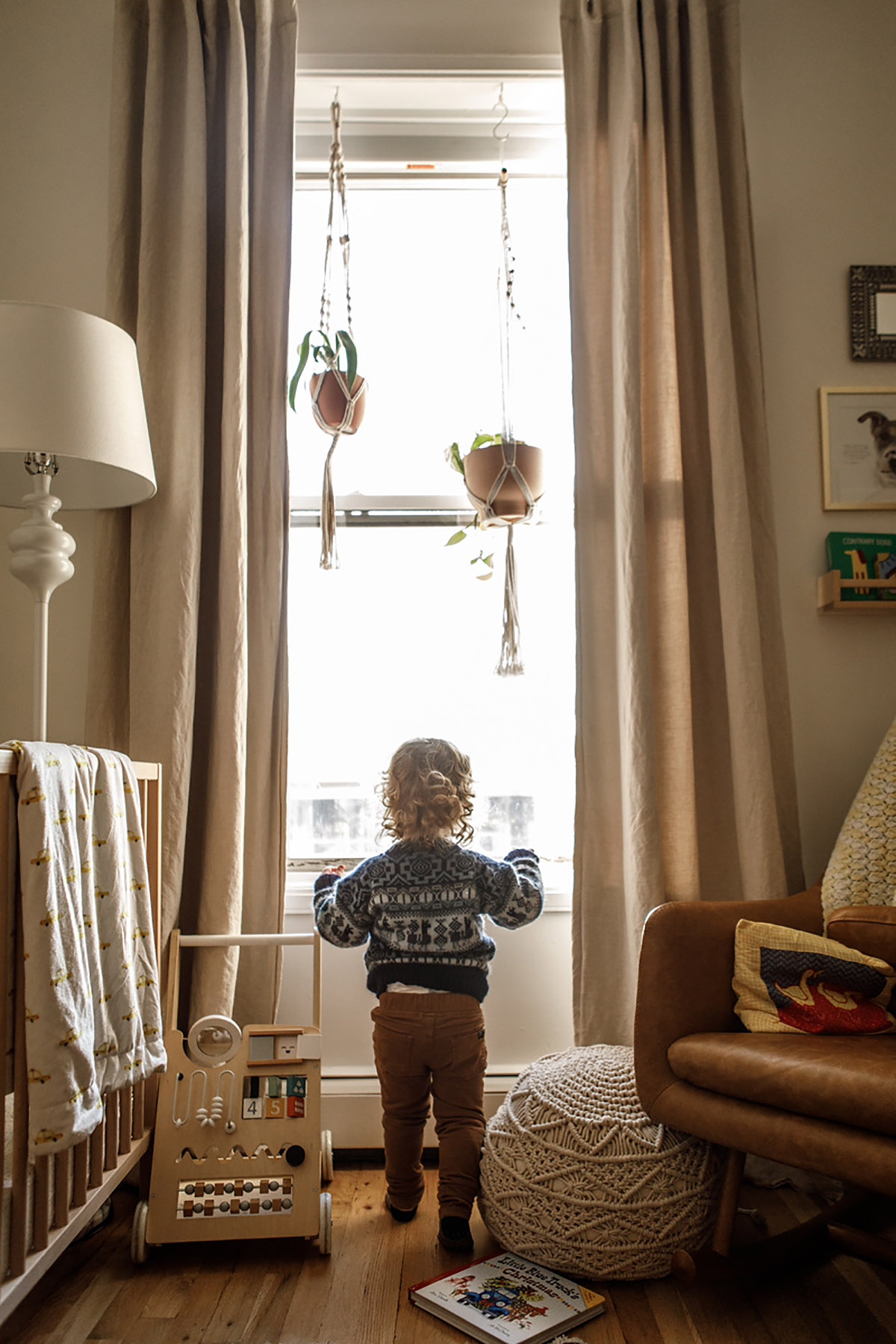 boy looking out the window in his nursery in Brooklyn