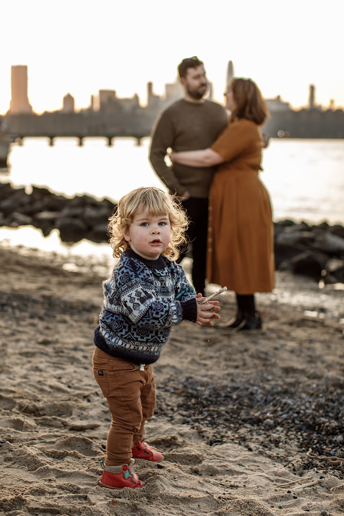 boy in dumbo with his parents in the background hugging each other