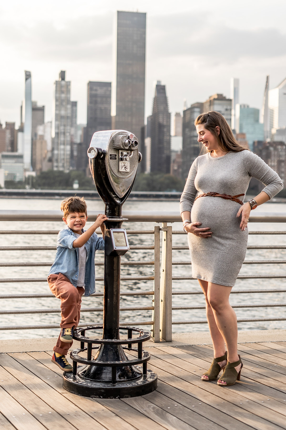 Pregnant mother and son in Hoboken by the water with nyc skyline in the background