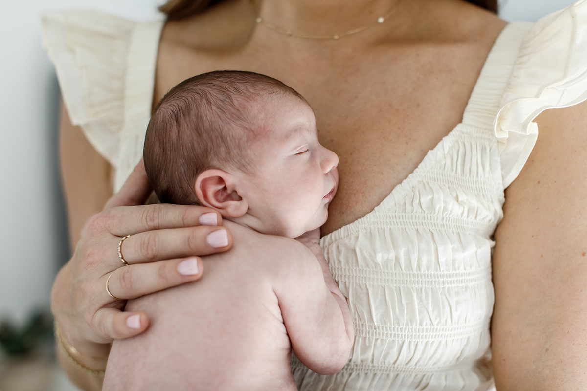 Sleeping newborn baby in her mother's arms