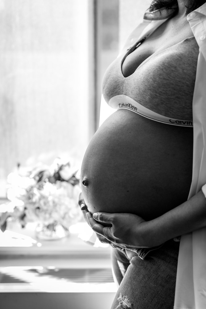 black and white photo of a pregnant belly