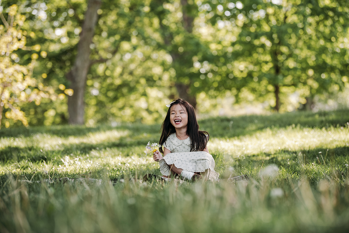 little girl laughing sitting in a park