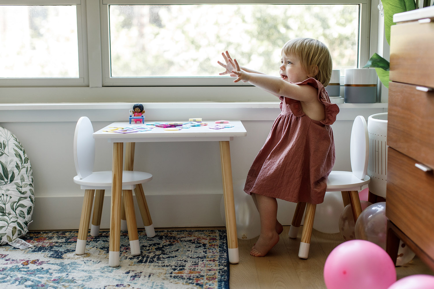 little girl in pink dress in nursery
