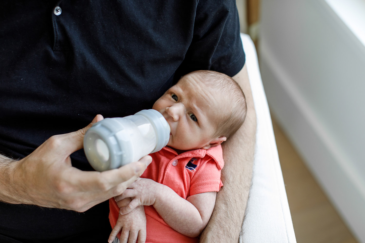 close up of little newborn baby boy being fed with bottle