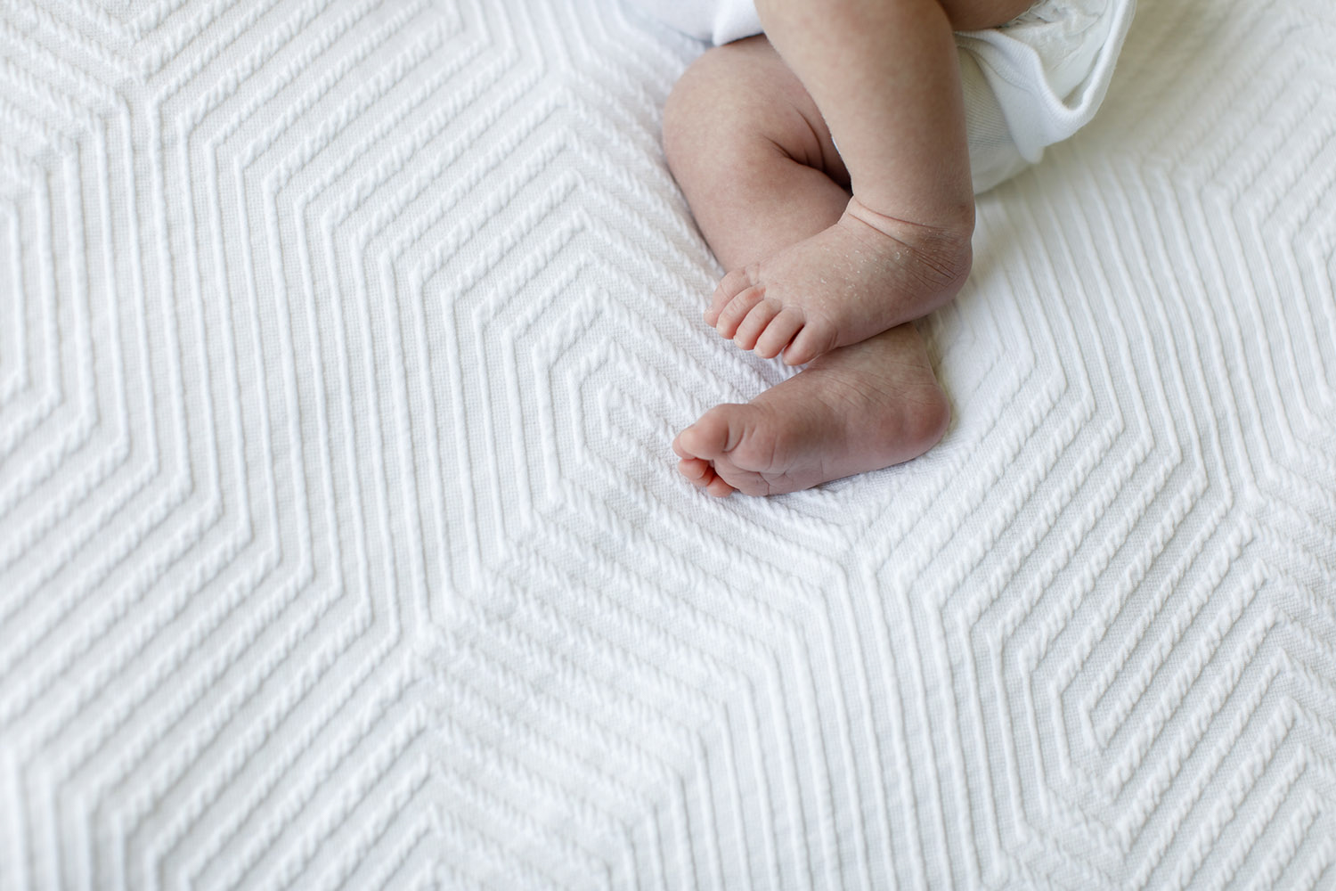 newborn baby feet on white blanket