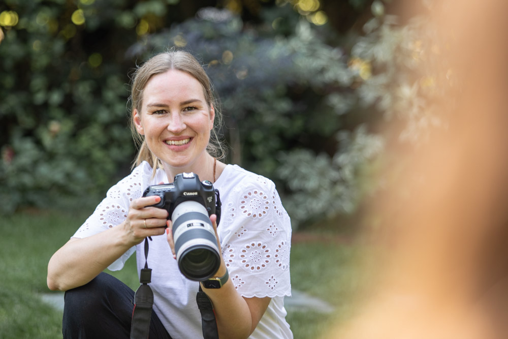 woman smiling holding a camera