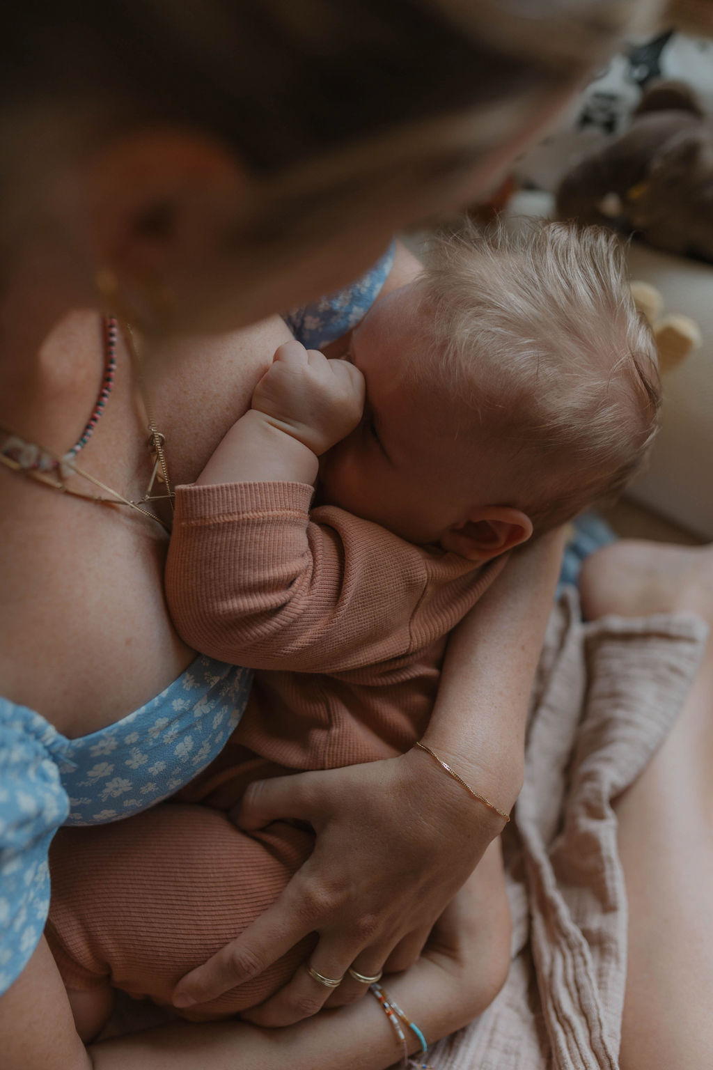 mom in blue dress breastfeeding her 3 month old baby boy