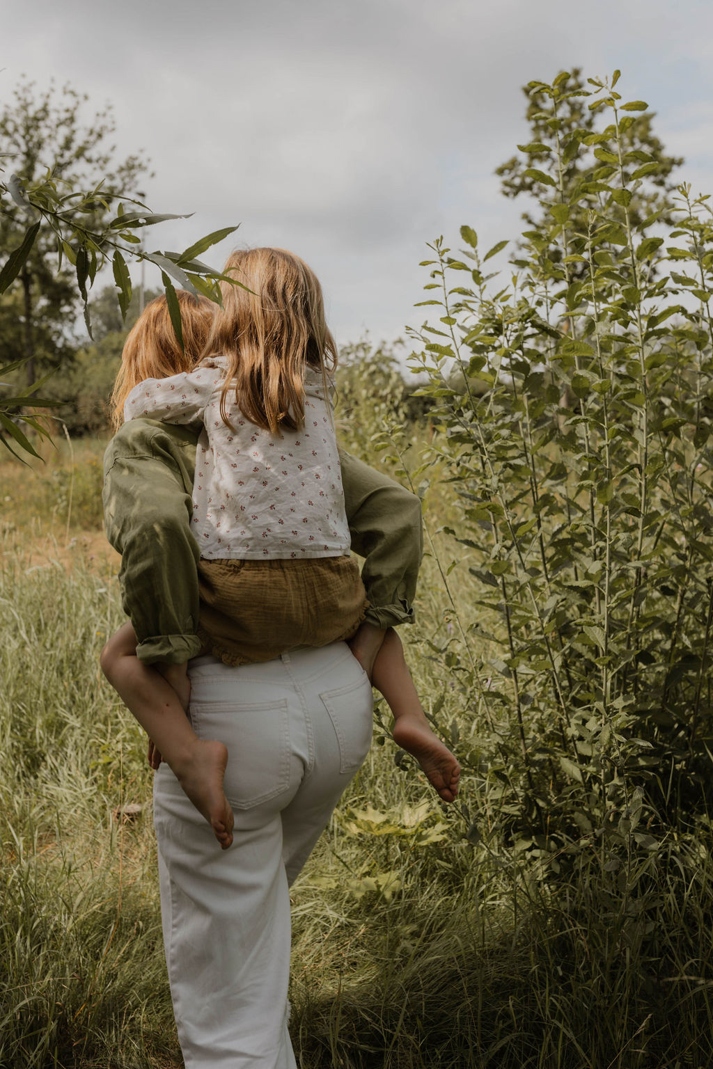 girl on a piggyback ride through nature with her mom