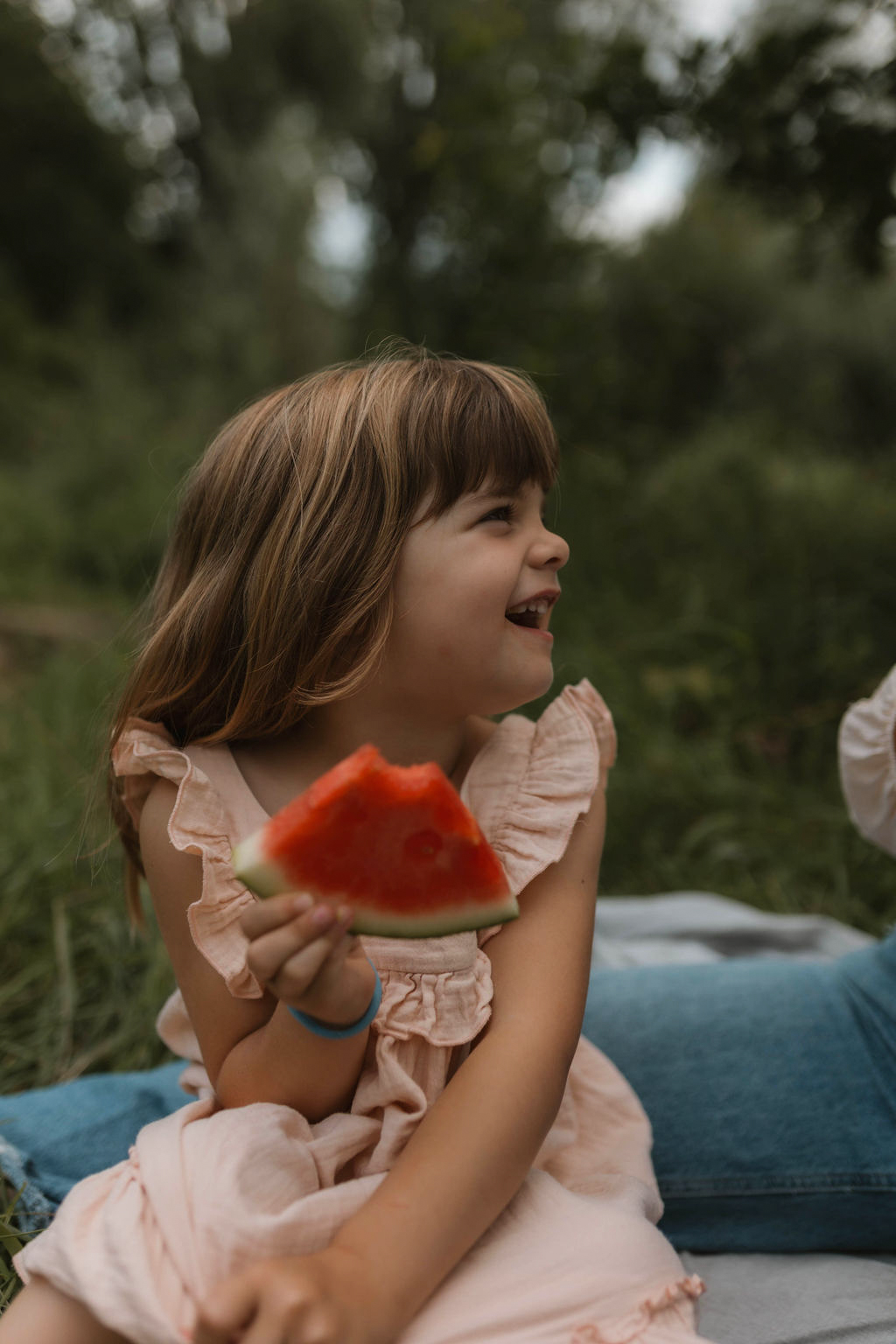 girl eating a watermelon and laughing