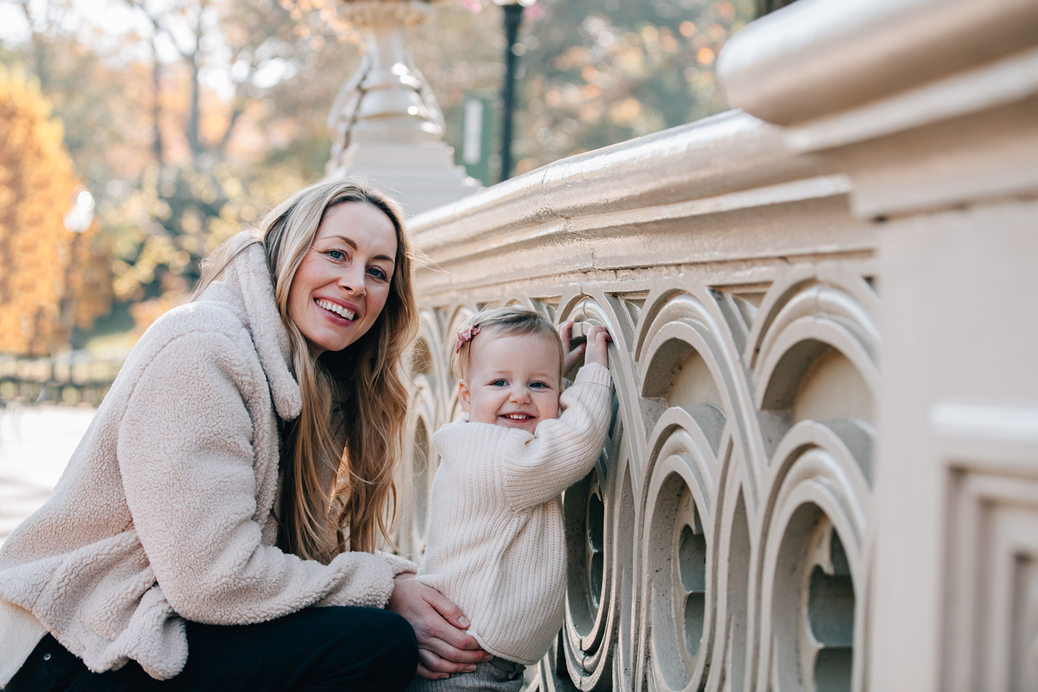 close up of mother and her daughter both smiling at the camera standing on a bridge in Central Park