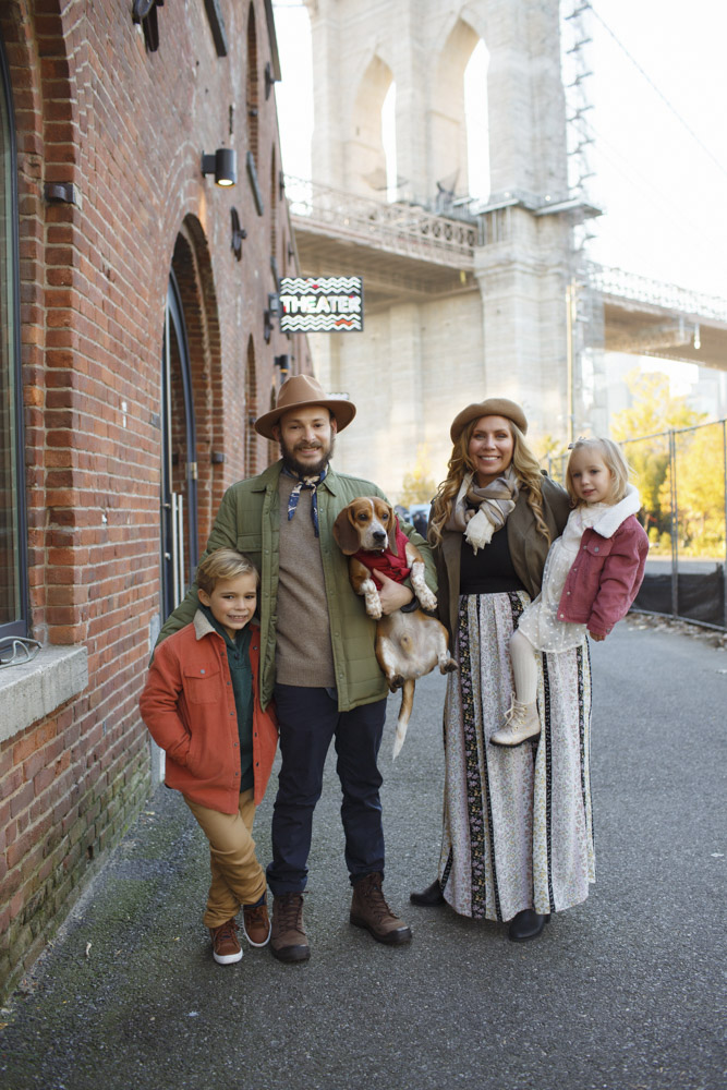 Family Session, family of four and their dog in the streets of Brooklyn smiling at the camera while mom is holding her daughter and dad is standing next to their son