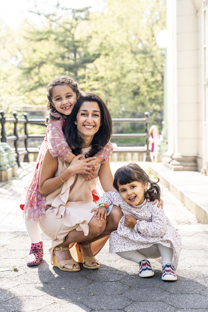Family Photography, mother and her two beautiful daughters are smiling at the camera wearing pretty dresses