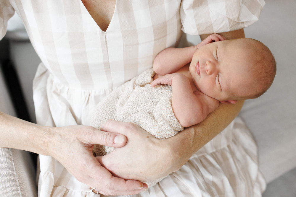 Baby Session, close up of mother holding her sleeping newborn in her arms close to her chest